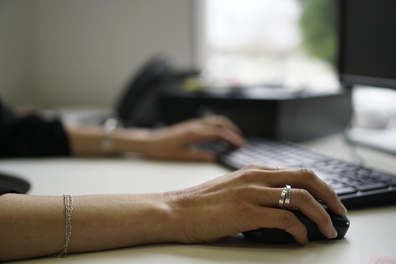 Student writing notes beside a laptop